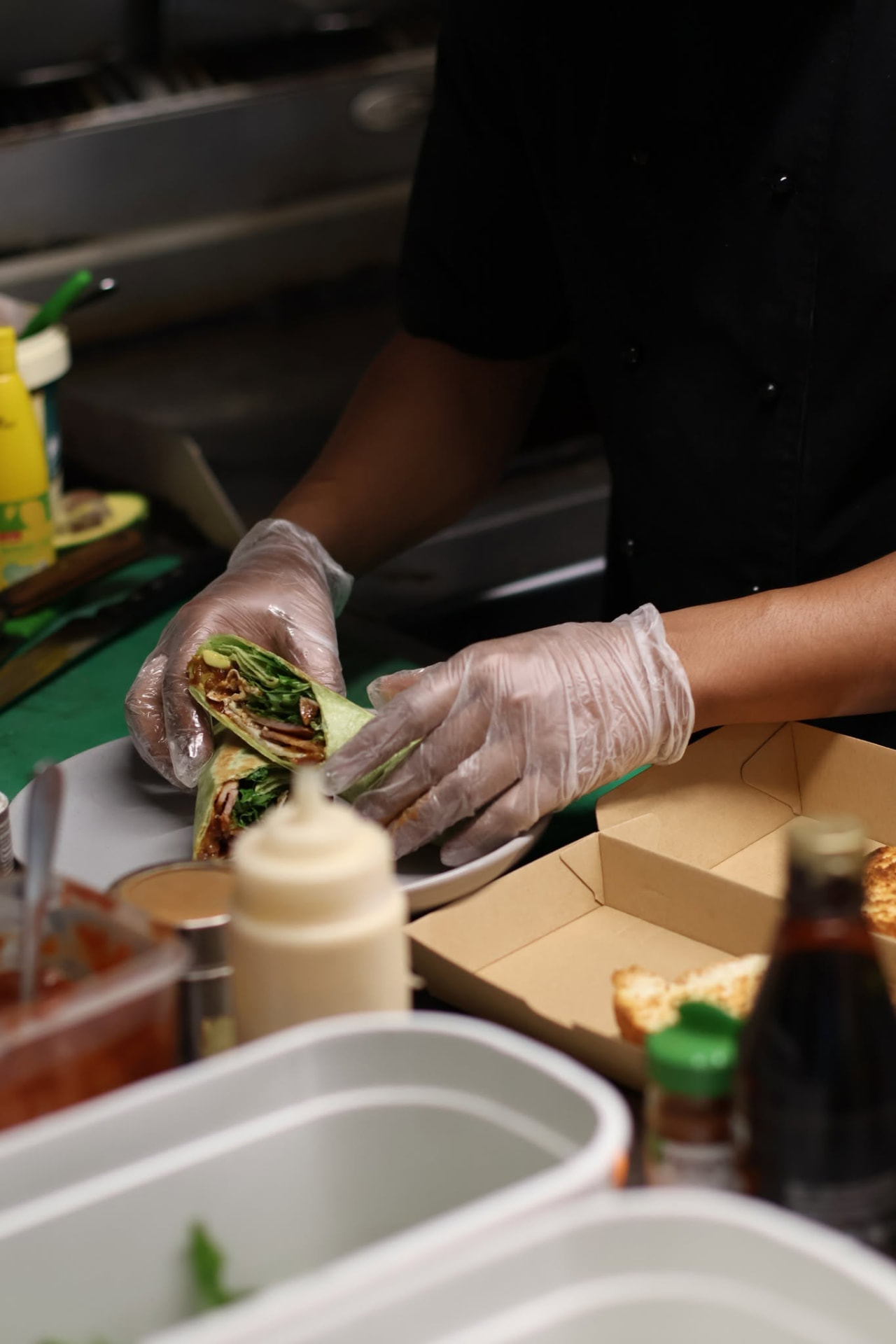 Chef wrapping a fresh chicken and salad wrap in the Alimento kitchen