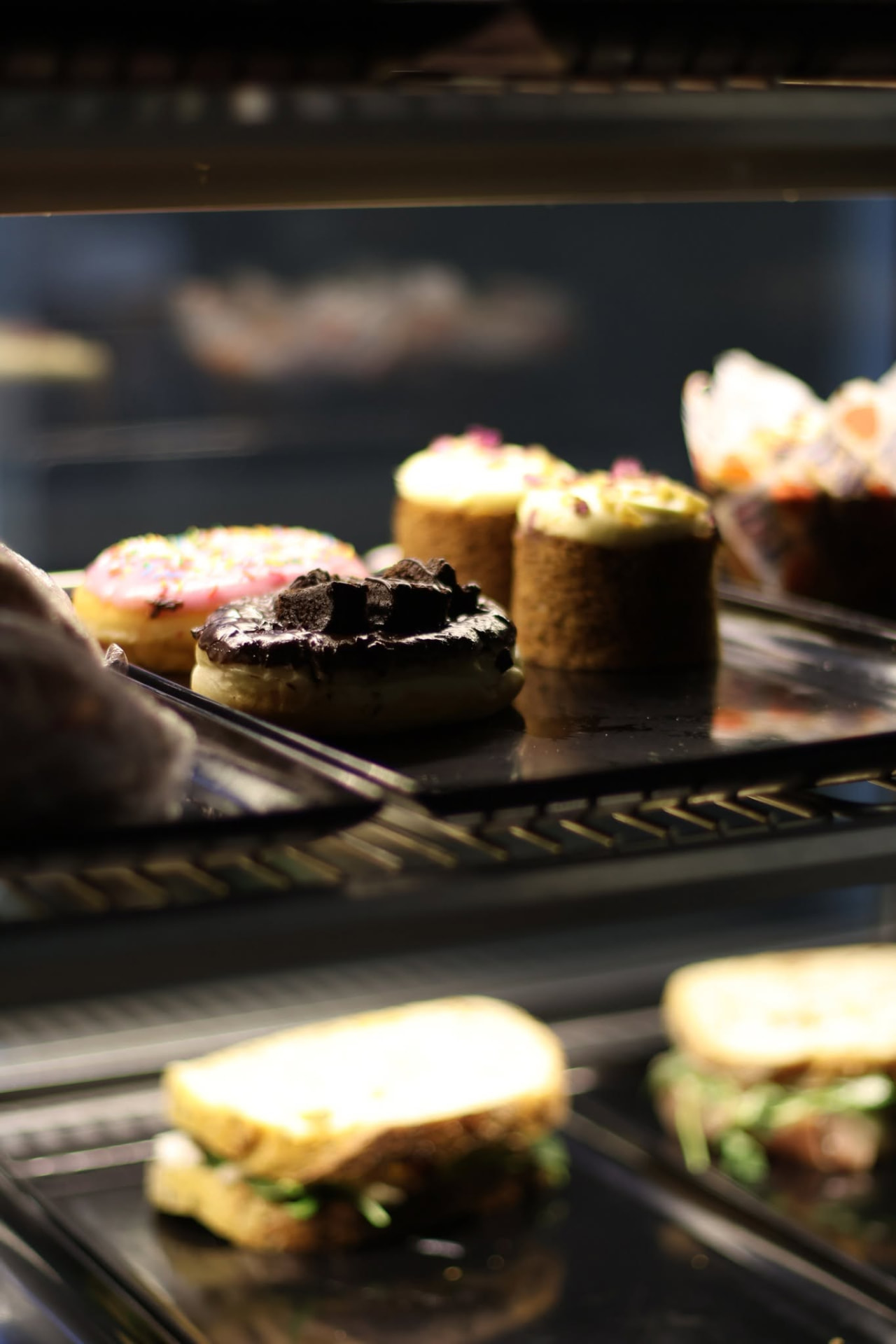 Cabinet display of doughnuts, cakes and fresh sandwiches