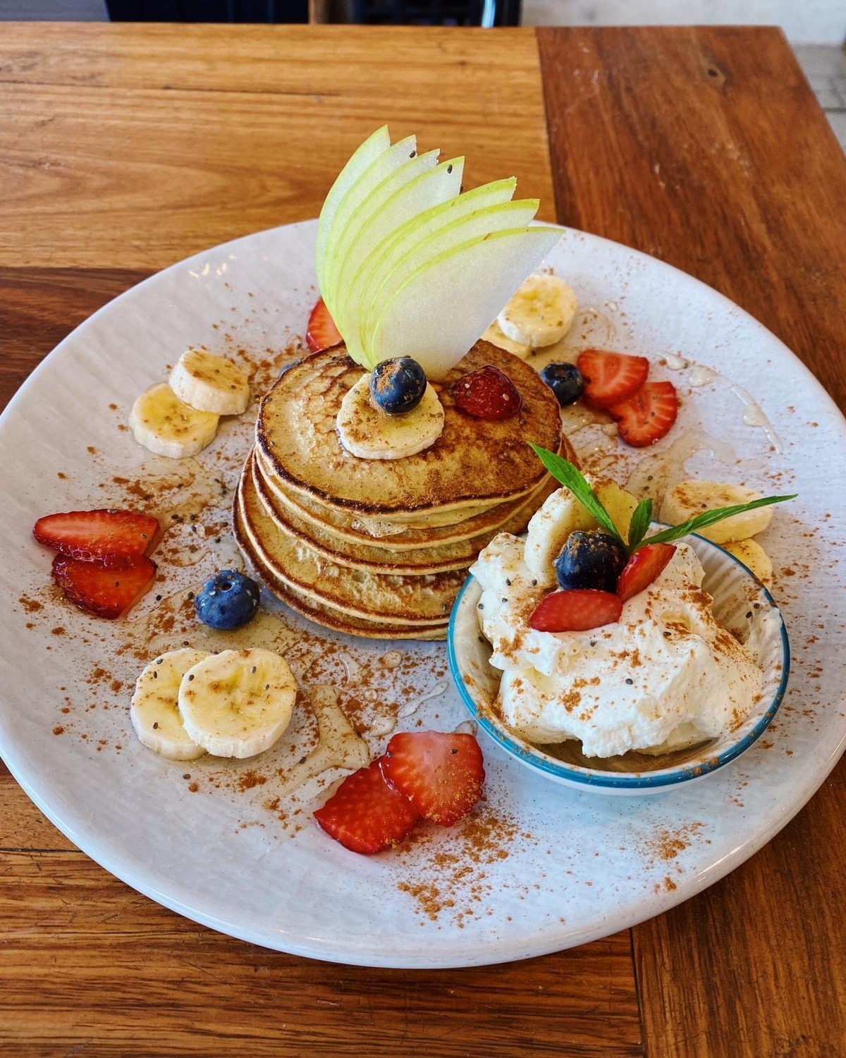Pancake stack with whipped cream, strawberries and banana